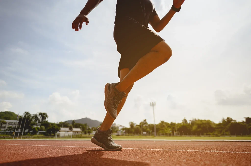 athletic adult running on an outdoor track